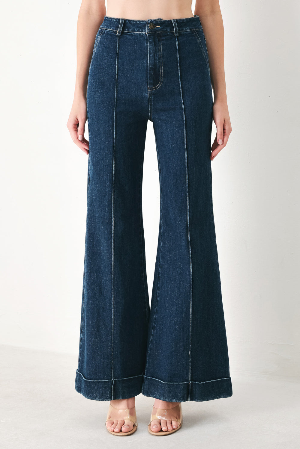 Woman wearing dark blue flared jeans featuring front closure, pockets, center seam | FREEMARKET | Flying Tomato