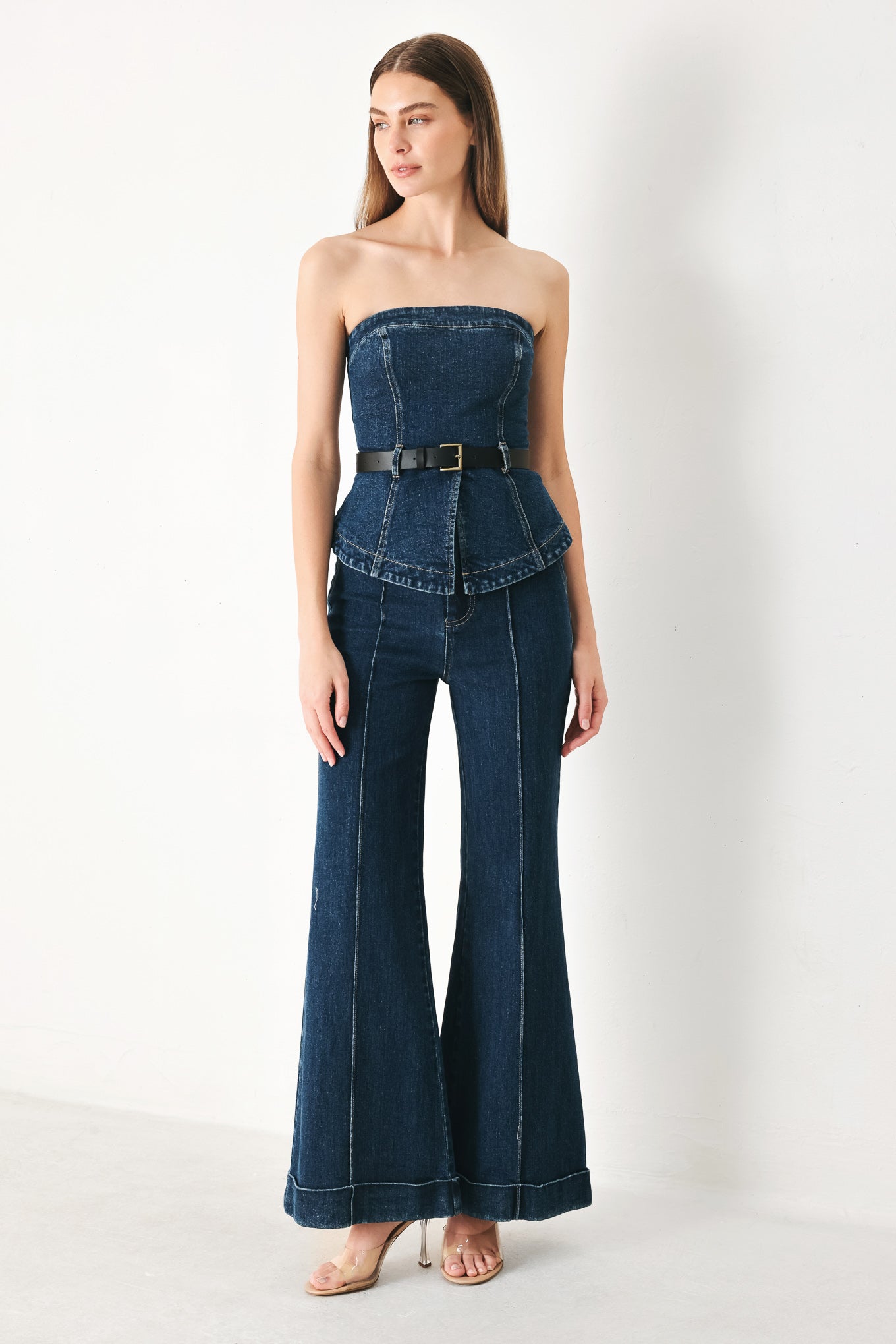 Woman wearing dark blue flared jeans featuring front closure, pockets, center seam | FREEMARKET | Flying Tomato