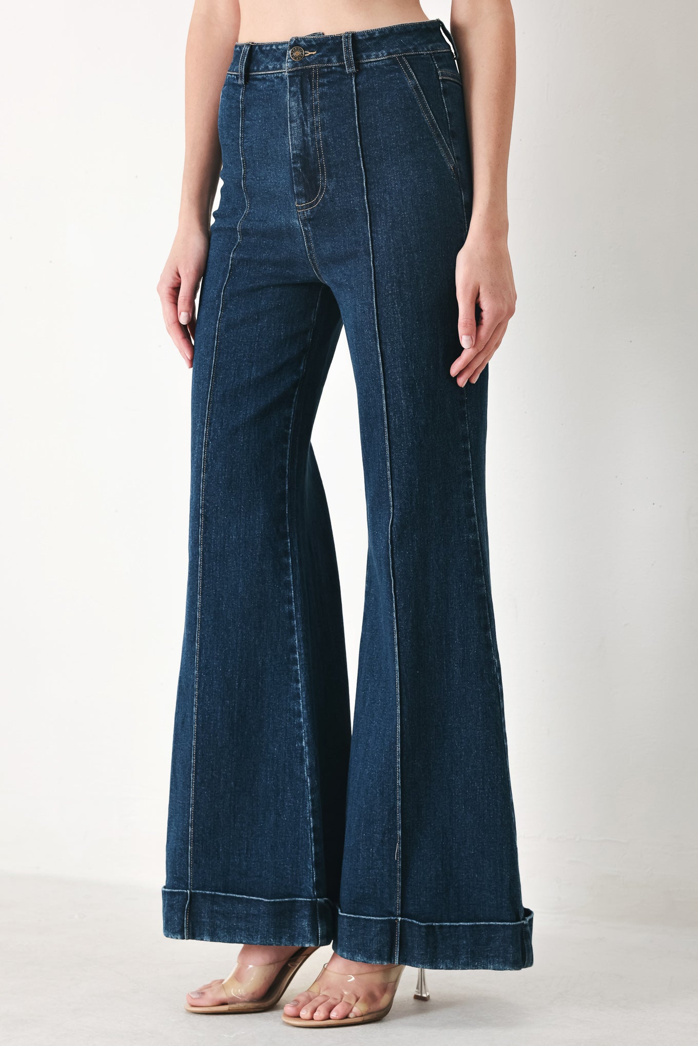 Woman wearing dark blue flared jeans featuring front closure, pockets, center seam | FREEMARKET | Flying Tomato