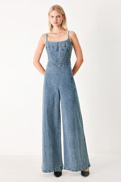 Woman wearing a denim jumpsuit featuring straight neckline, straps, wide leg and back zipper closure | FREEMARKET