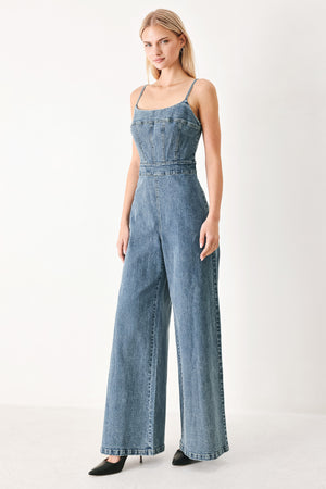 Woman wearing a denim jumpsuit featuring straight neckline, straps, wide leg and back zipper closure | FREEMARKET