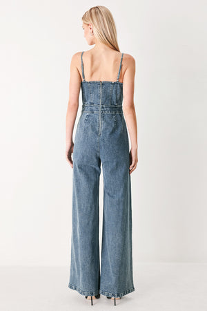 Woman wearing a denim jumpsuit featuring straight neckline, straps, wide leg and back zipper closure | FREEMARKET