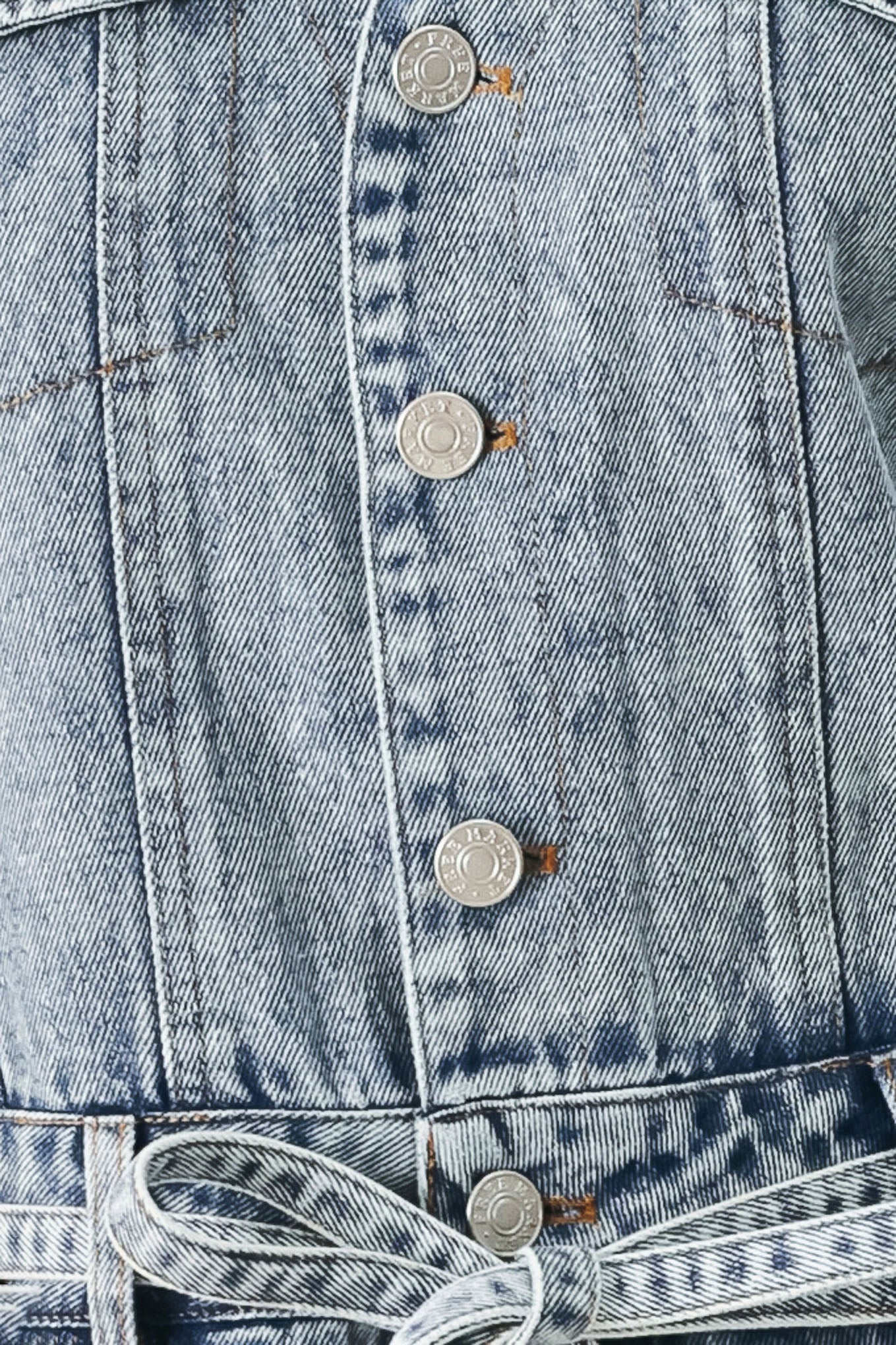 Woman wearing a denim romper with collar, sleeveless, button down, self tie and pockets | FREEMARKET