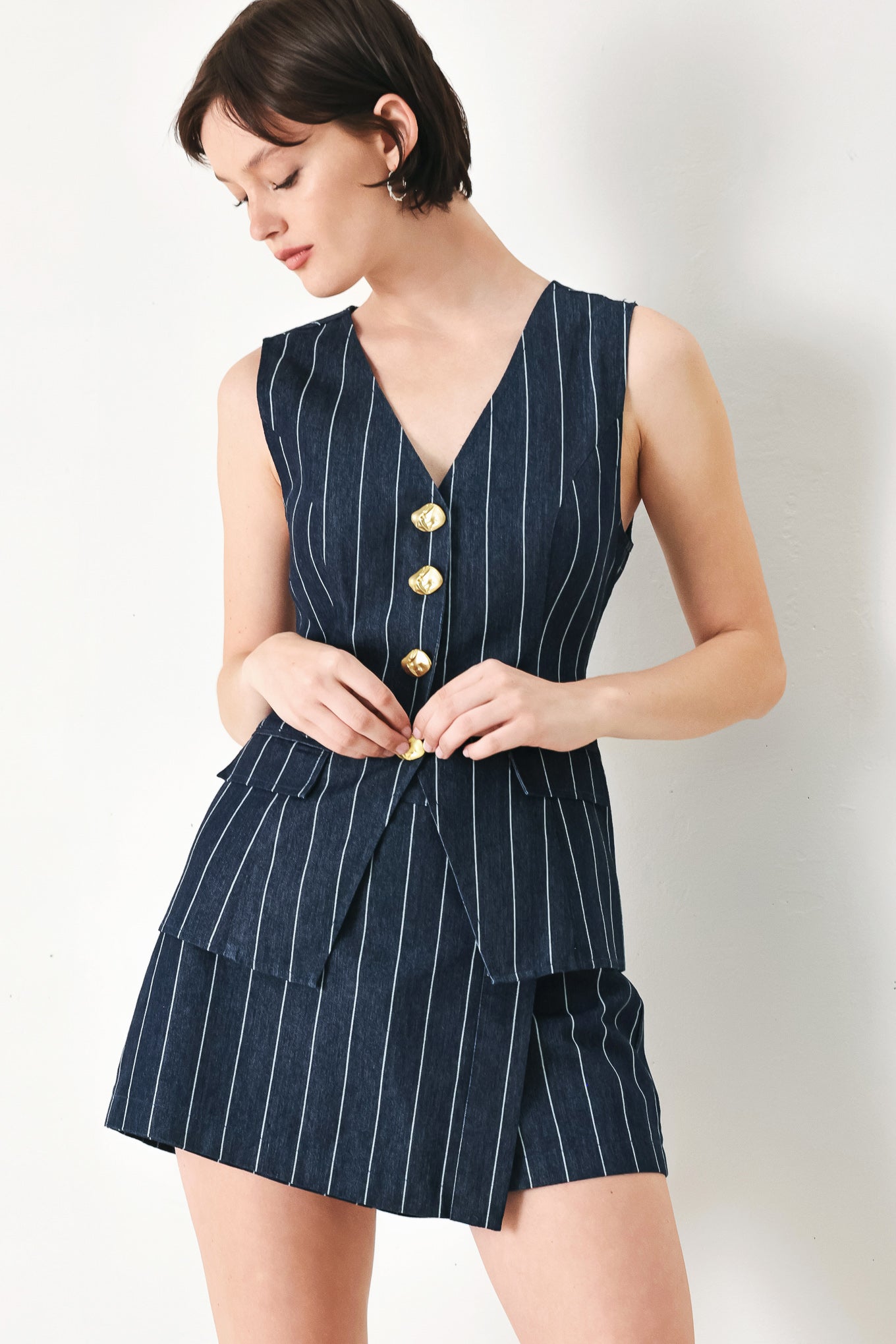 A striped woven skort with front closure and button detail.