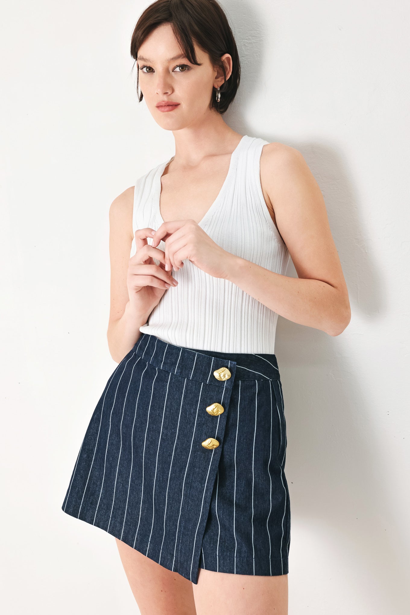 A striped woven skort with front closure and button detail.
