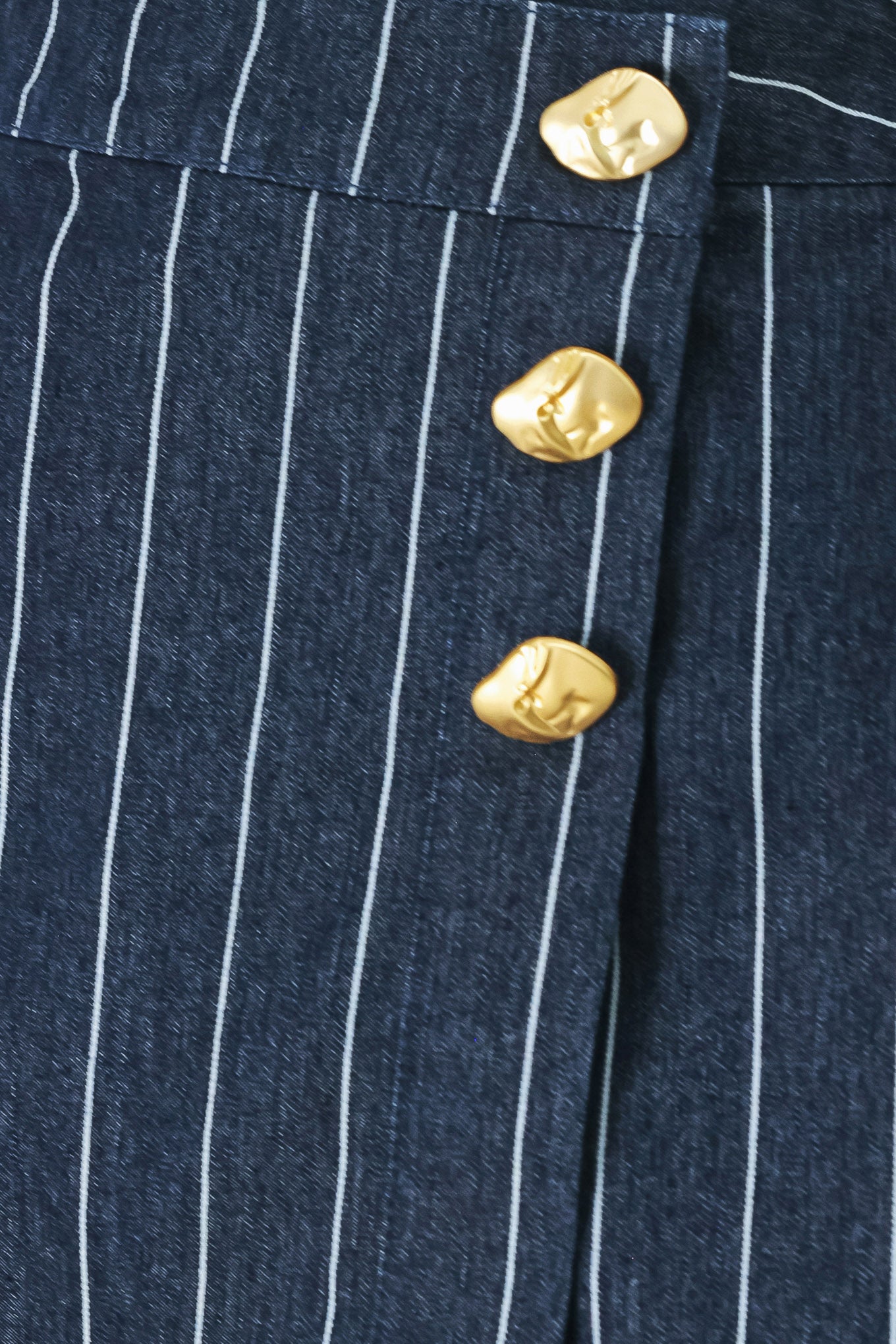 A striped woven skort with front closure and button detail.