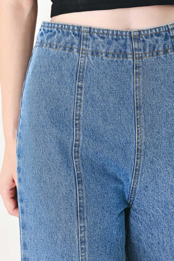A washed denim pant with elastic waist and wide leg. 