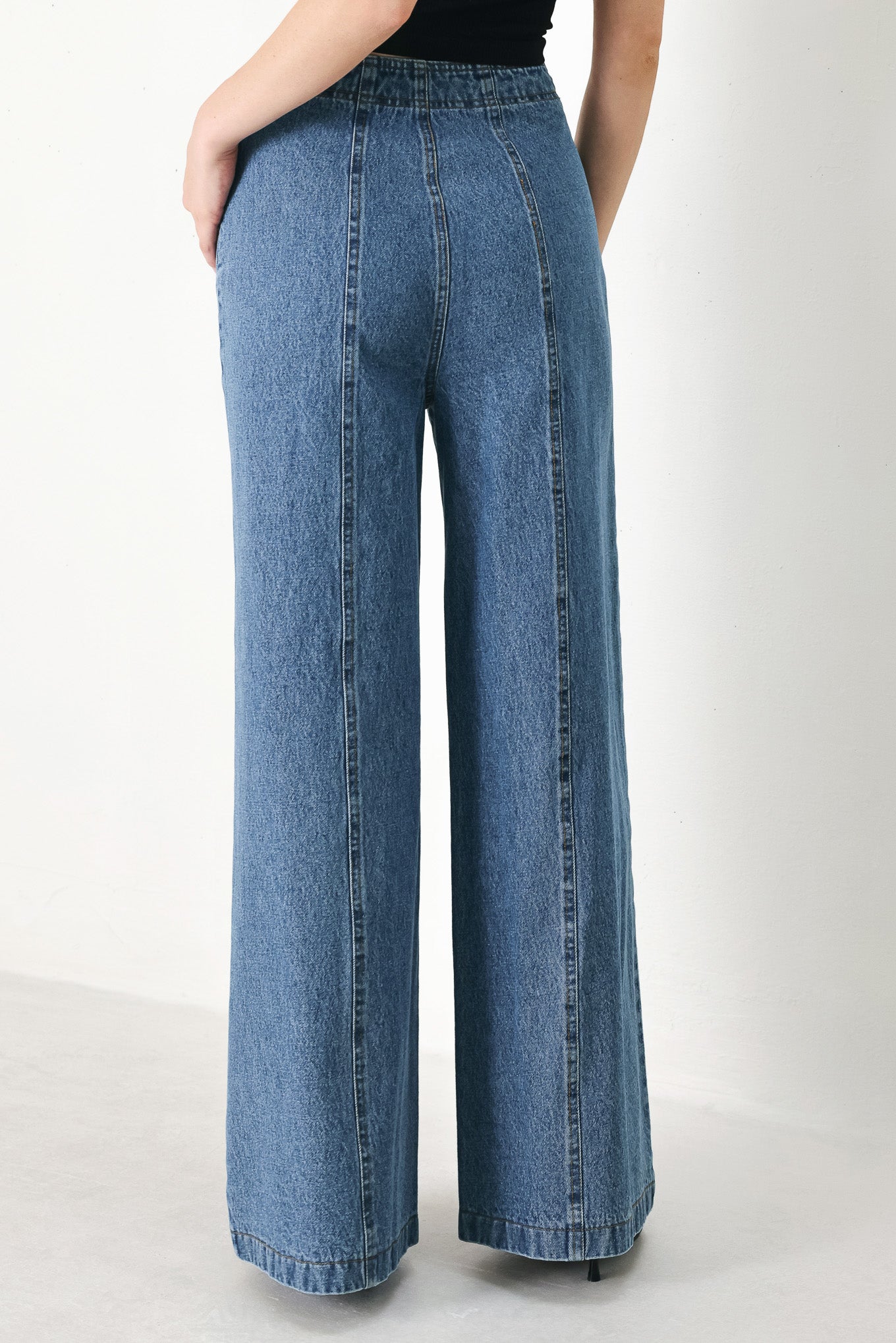 A washed denim pant with elastic waist and wide leg. 