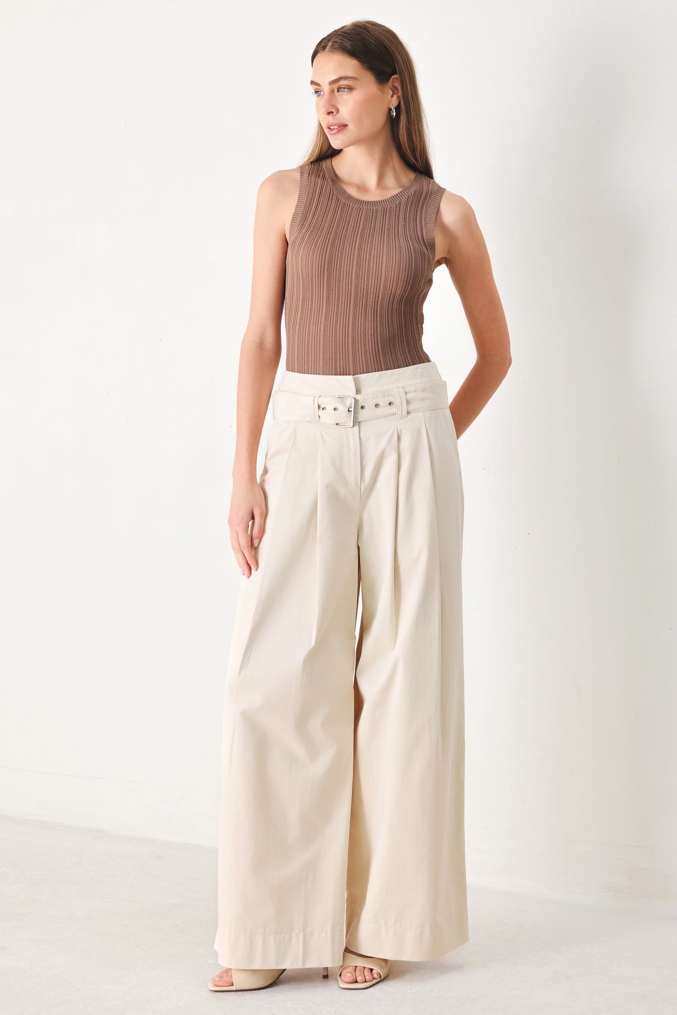 Woman wearing beige wide-leg pants with self belt, front closure and pockets | FREEMARKET | Flying Tomato