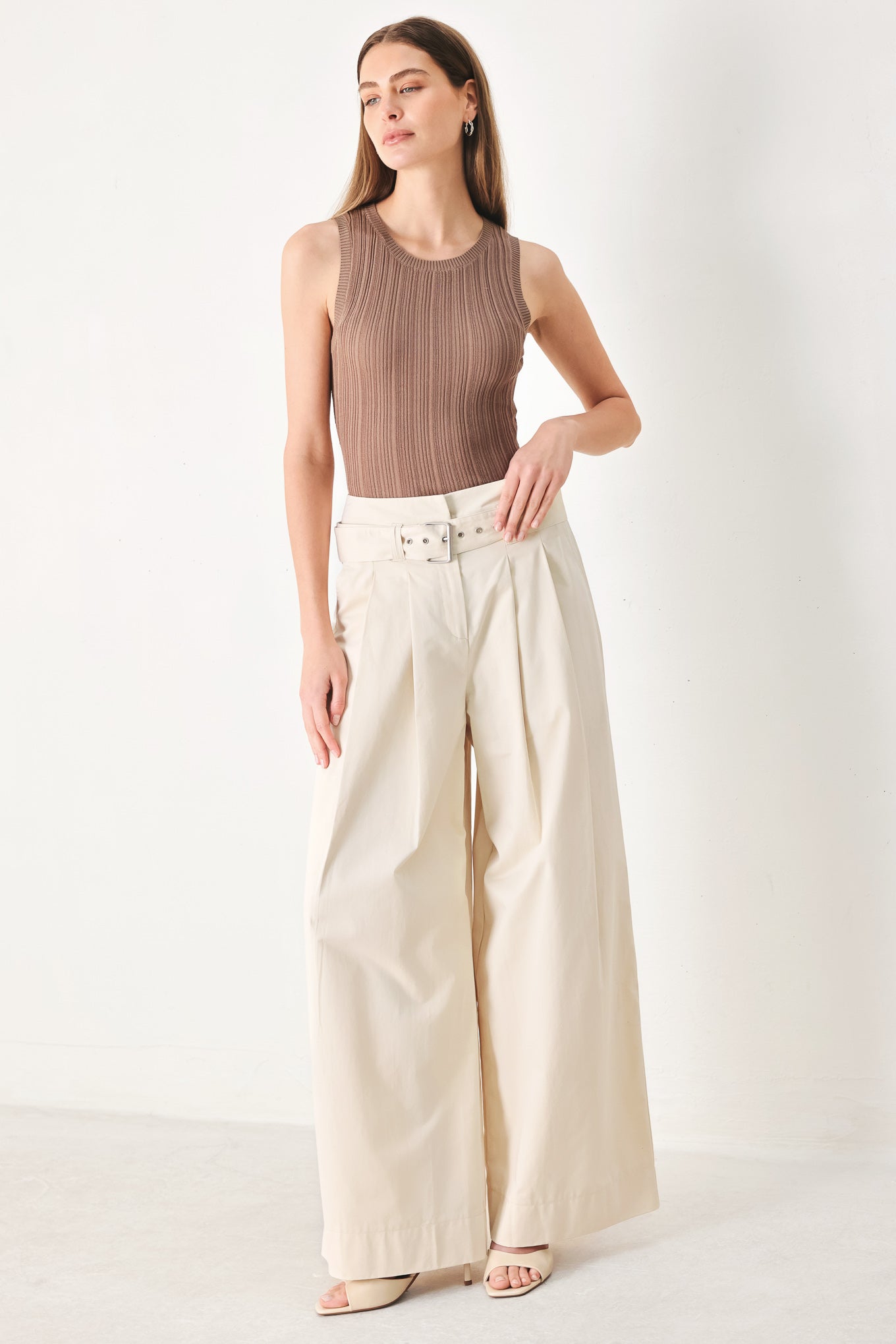 Woman wearing beige wide-leg pants with self belt, front closure and pockets | FREEMARKET | Flying Tomato