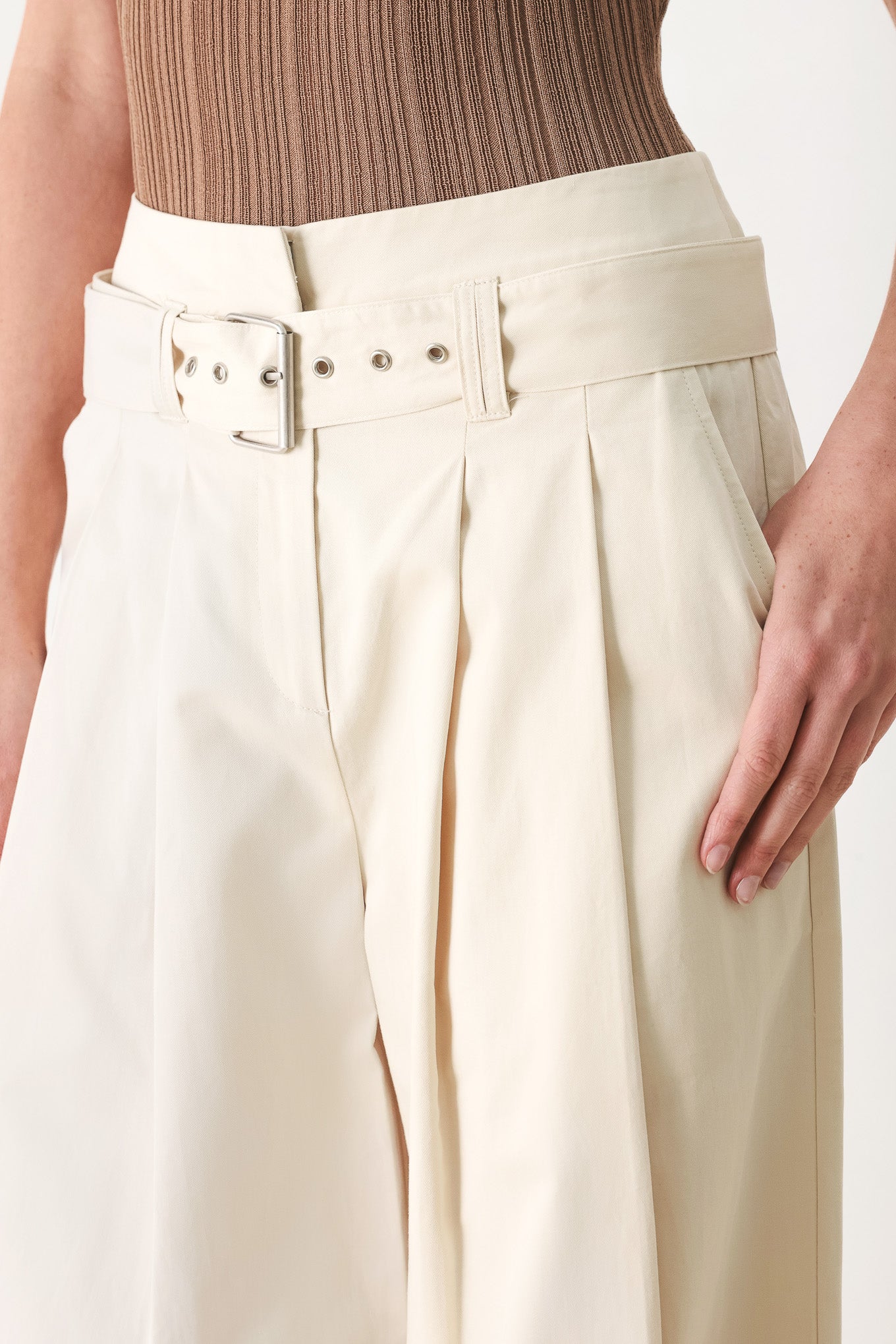 Woman wearing beige wide-leg pants with self belt, front closure and pockets | FREEMARKET | Flying Tomato