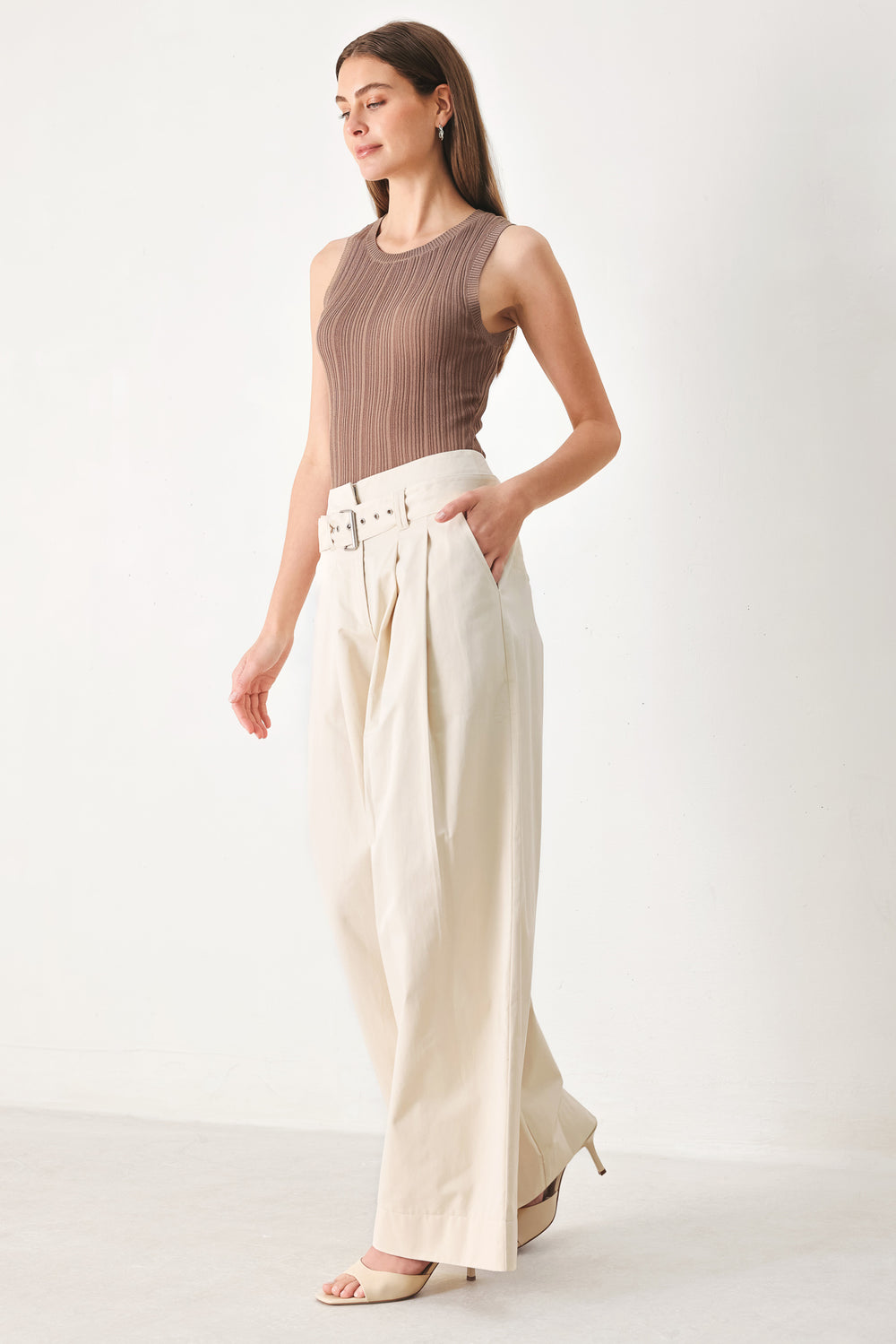 Woman wearing beige wide-leg pants with self belt, front closure and pockets | FREEMARKET | Flying Tomato