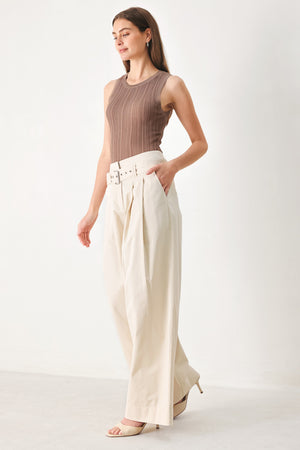 Woman wearing beige wide-leg pants with self belt, front closure and pockets | FREEMARKET | Flying Tomato