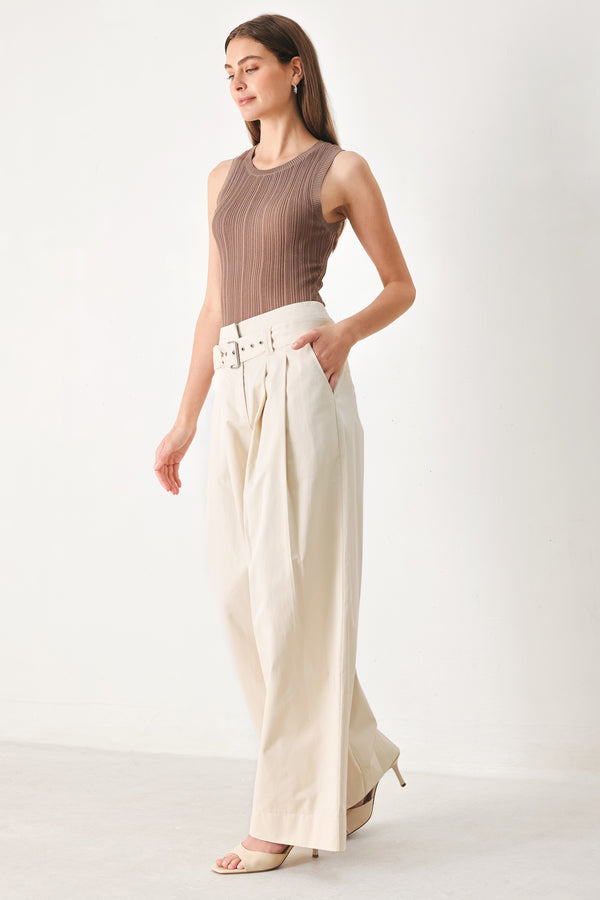 Woman wearing beige wide-leg pants with self belt, front closure and pockets | FREEMARKET | Flying Tomato