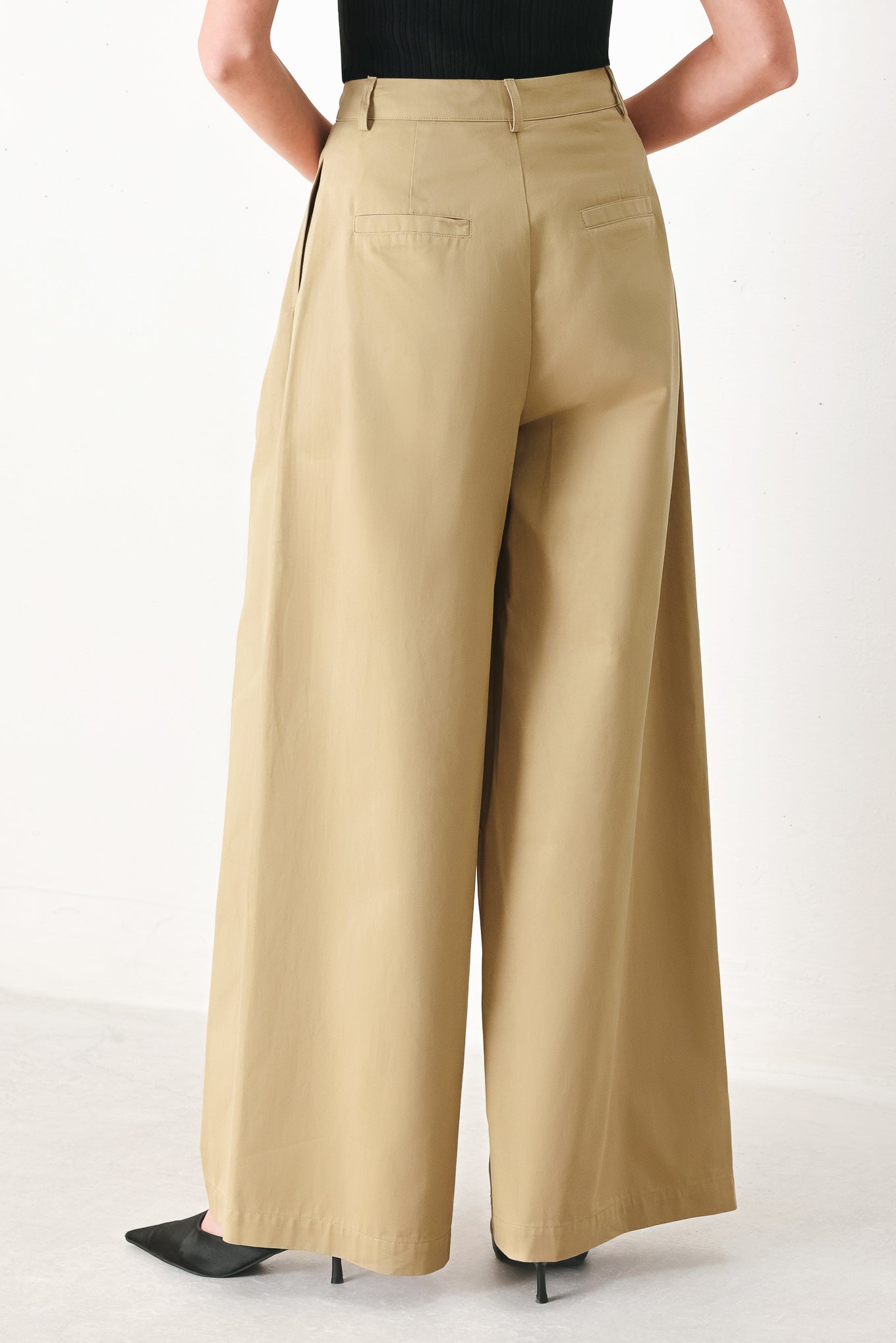 Woman wearing beige wide-leg pants with front closure, side pocket | FREEMARKET | Flying Tomato