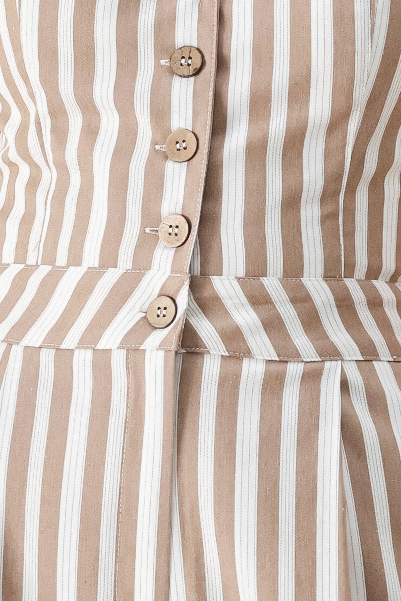 Close up of a striped woven jumpsuit featuring V neckline, sleeveless, front button/zipper closure and wide leg | FREEMARKET