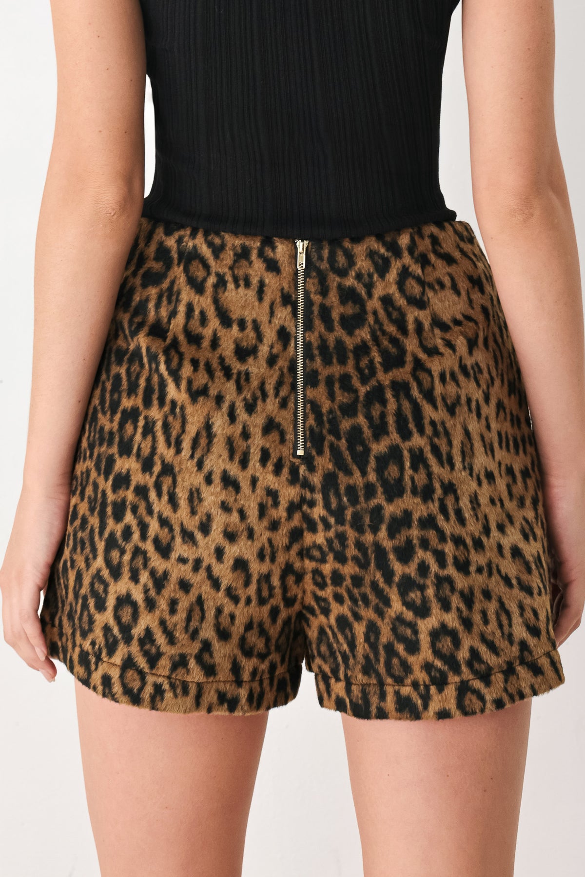 A model wearing a brown leopard-print mini skirt with two front button details | FREEMARKET