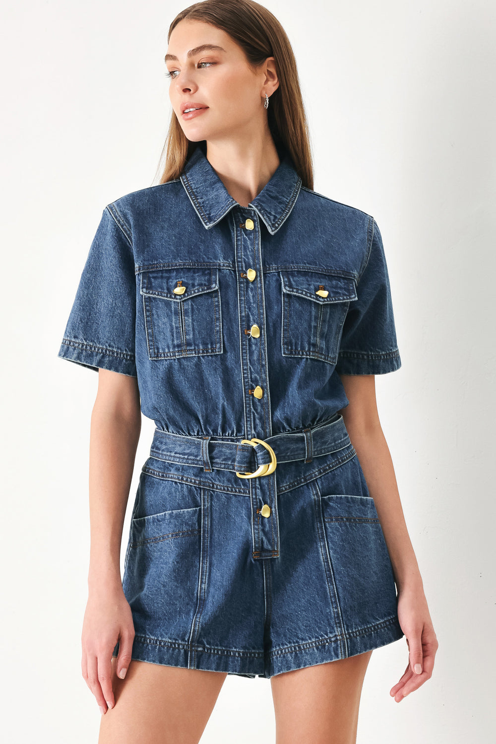 Woman wearing a denim romper featuring collar, button down closure, short sleeve, pockets and belt | FFREEMARKET | Flying Tomato