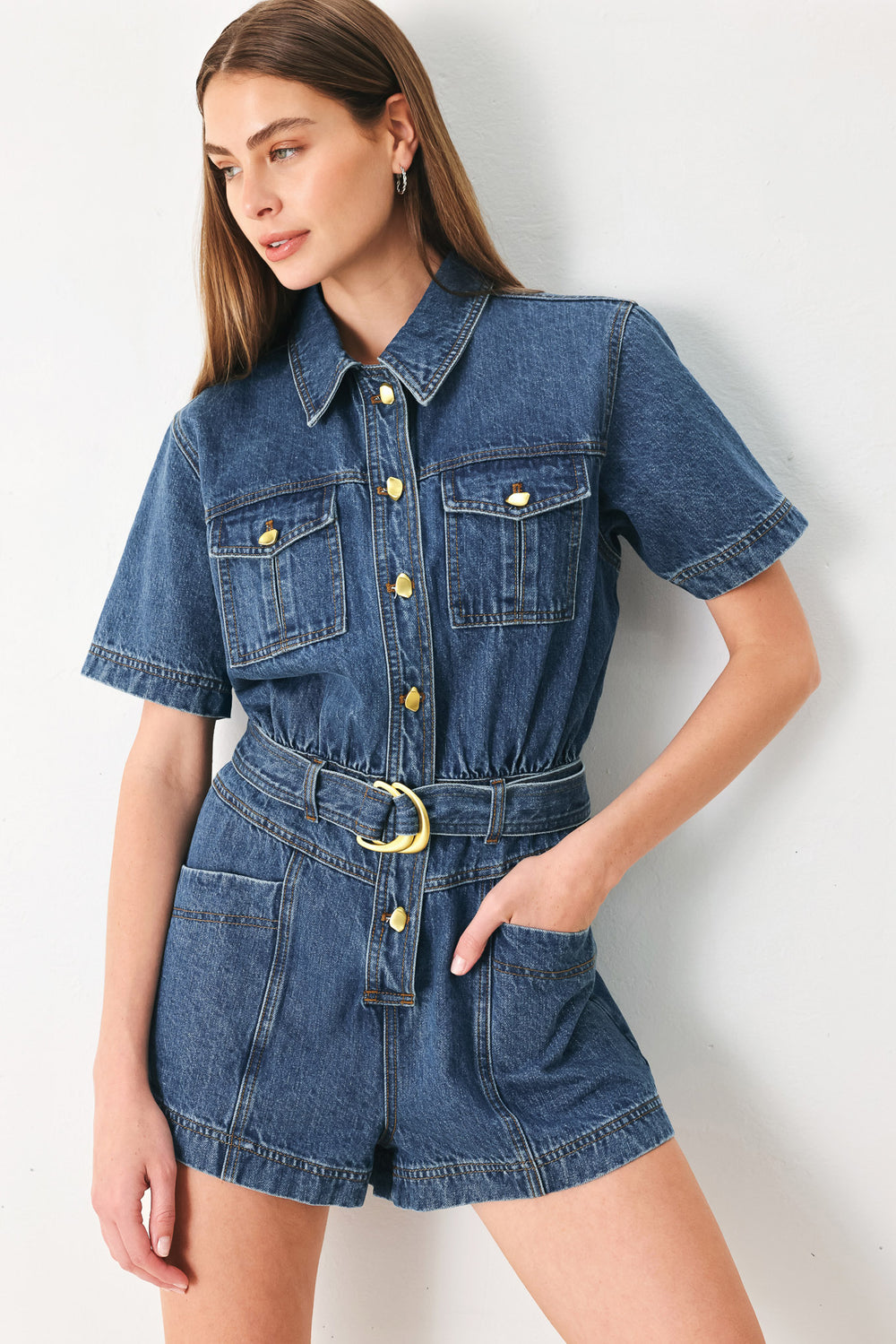 Woman wearing a denim romper featuring collar, button down closure, short sleeve, pockets and belt | FFREEMARKET | Flying Tomato