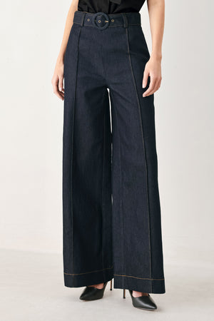 Woman wearing dark denim wide-leg pants with front closure, self belt | FREEMARKET