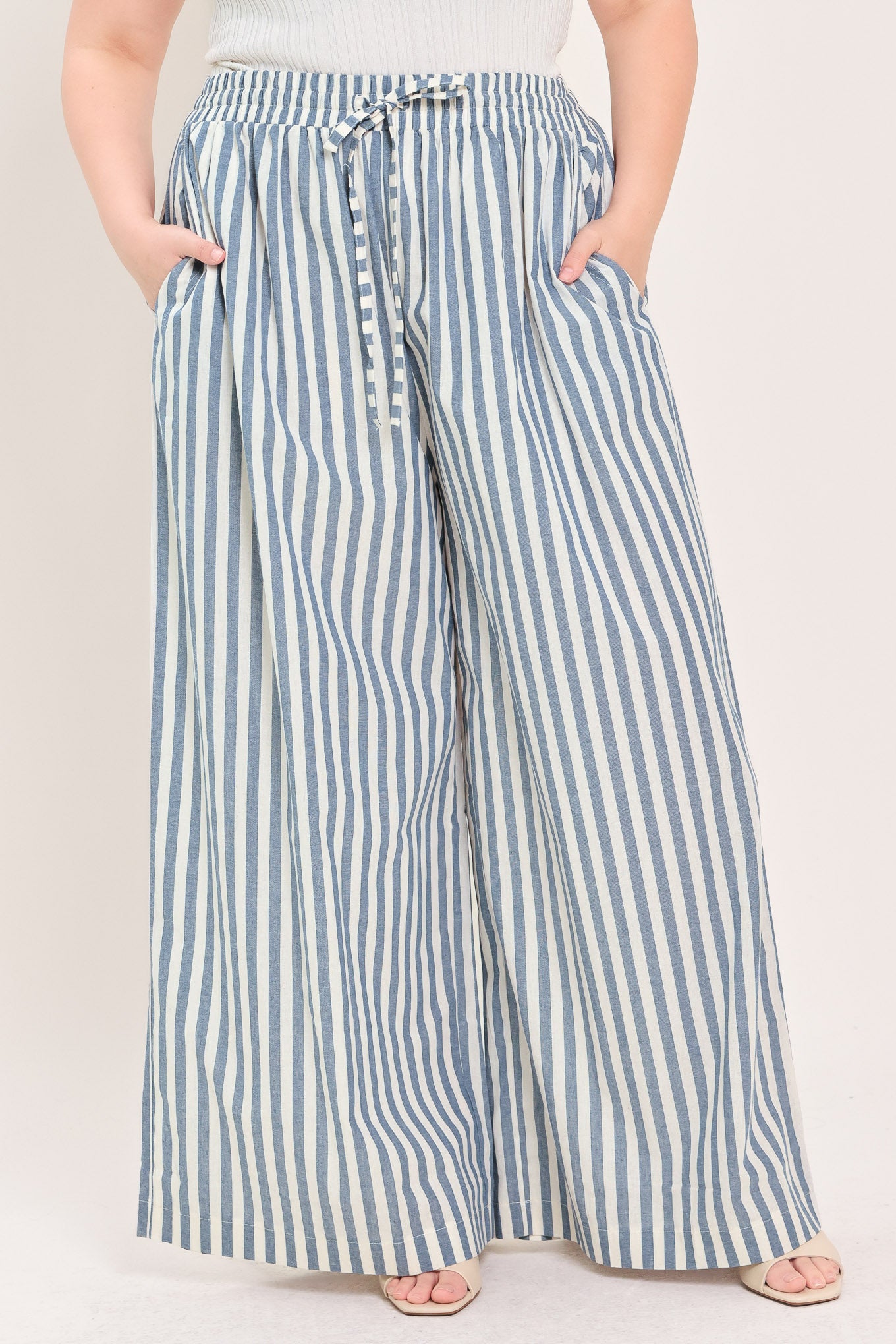 Woman wearing striped woven pant featuring front pleat, side pockets, wide leg and elastic back waistband | FREEMARKET