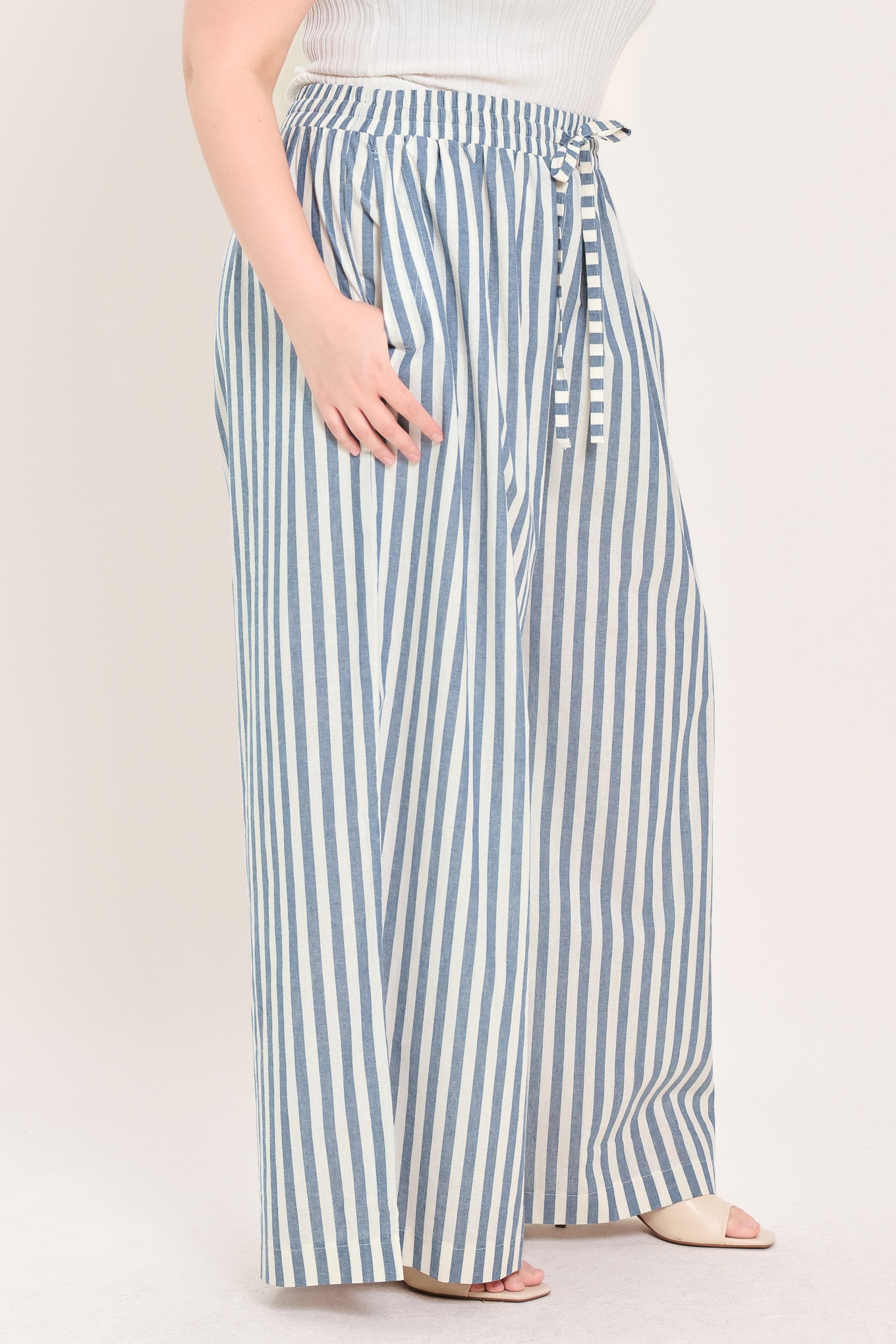 Woman wearing striped woven pant featuring front pleat, side pockets, wide leg and elastic back waistband | FREEMARKET