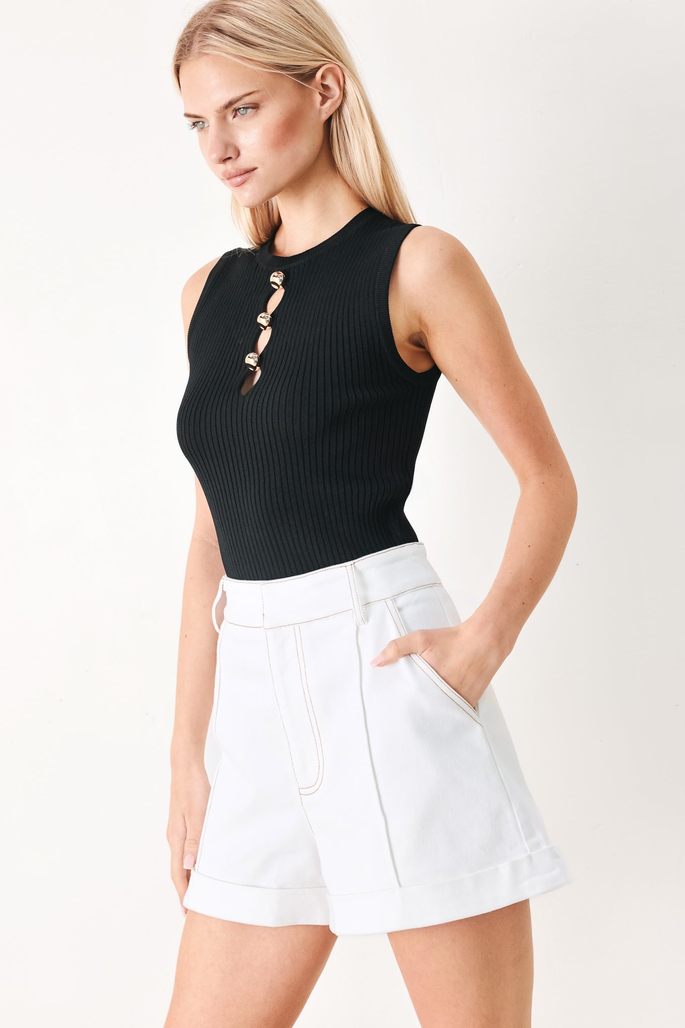 Woman wearing white woven shorts with front closure, side pockets and cuffed hem | FREEMARKET