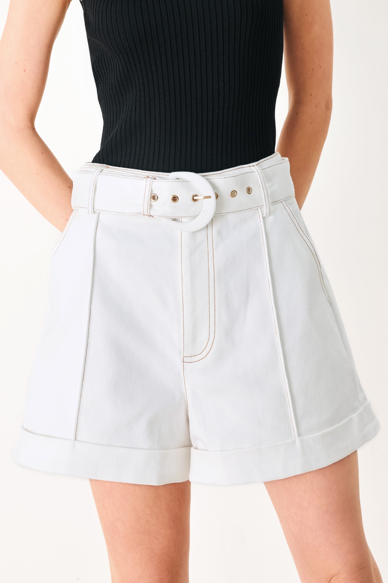 Woman wearing white woven shorts with front closure, side pockets and cuffed hem | FREEMARKET