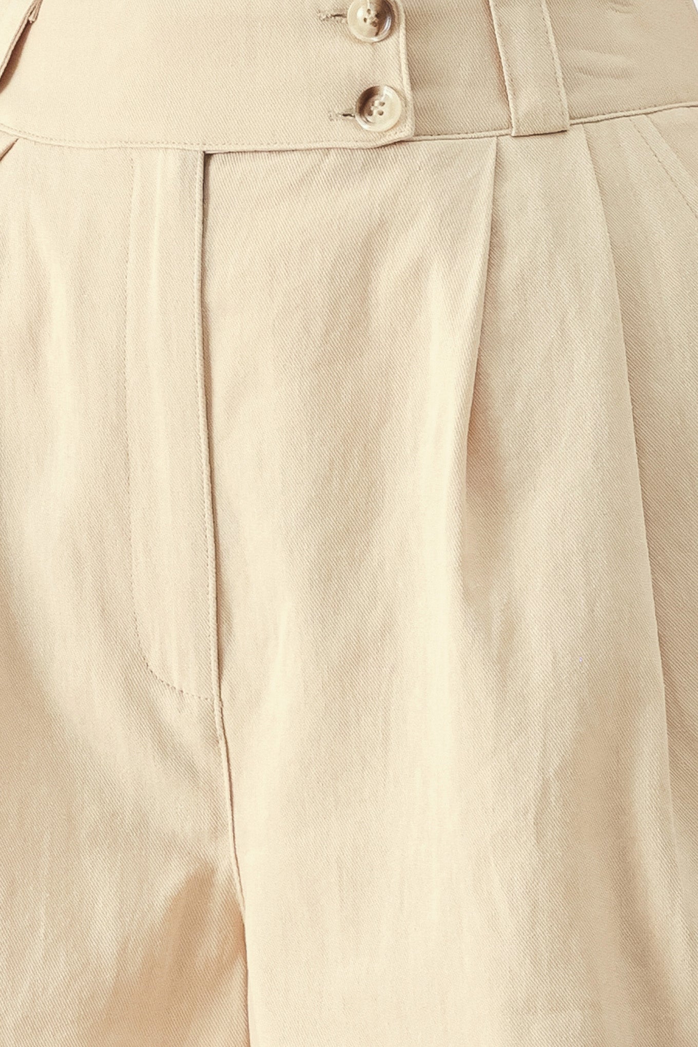 Close up of light beige woven shorts with front closure, pockets and cuff hem | FEEMARKET