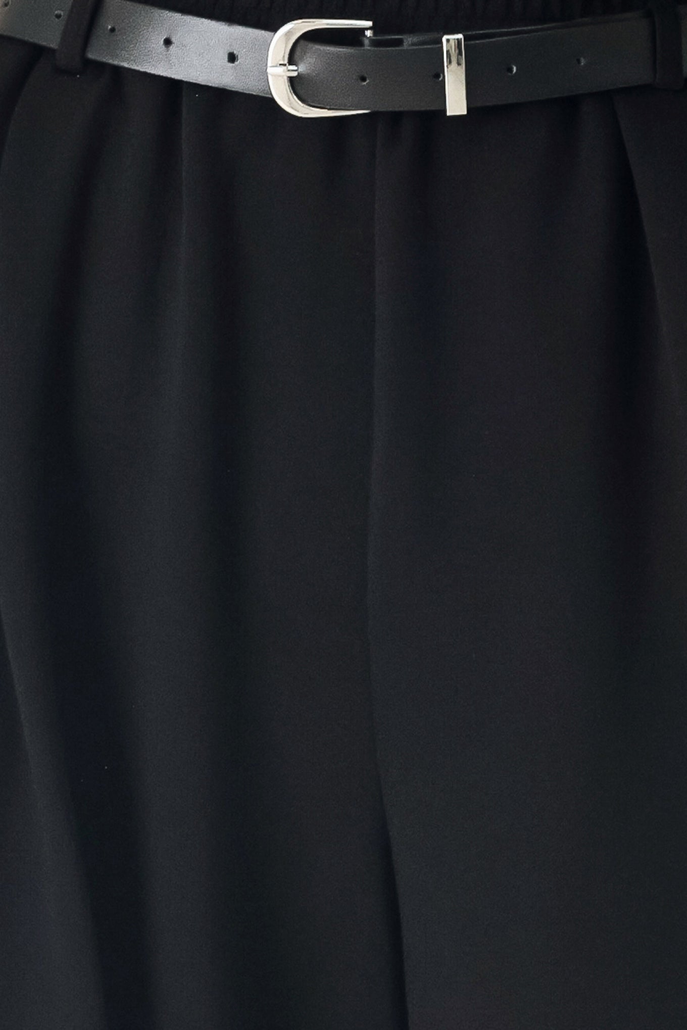 Woman wearing black wide-leg pants with a self tie belt | FREEMARKET