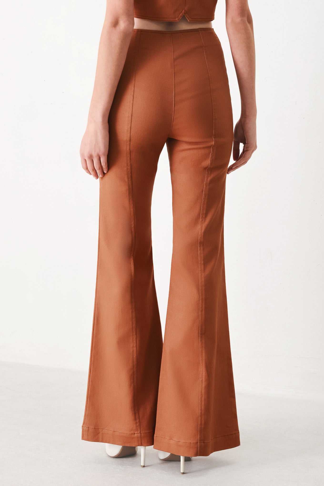 Woman wearing terracotta flared pants with belt tab, front zipper and flare leg | FREEMARKET | Flying Tomato