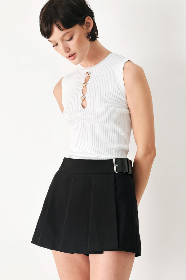 Woman wearing a black pleated skort with a belt buck off side | FREEMARKET