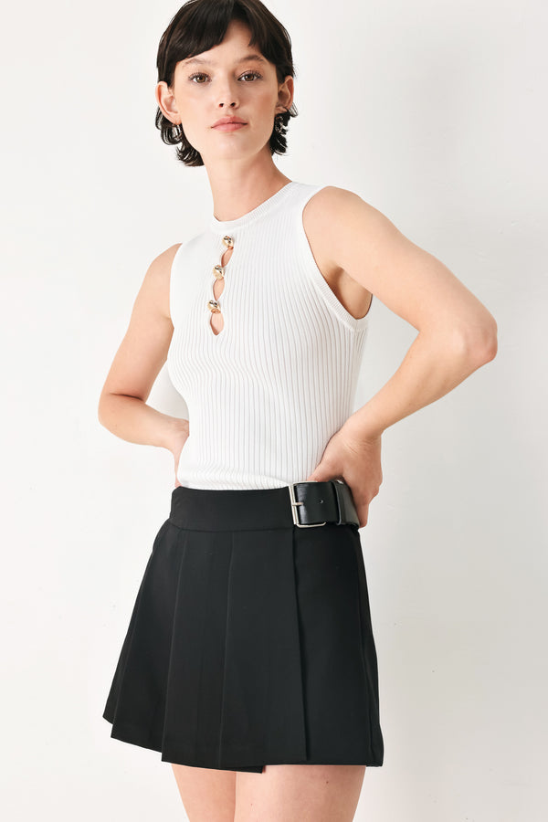 Woman wearing a black pleated skort with a belt buck off side | FREEMARKET