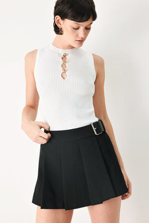 Woman wearing a black pleated skort with a belt buck off side | FREEMARKET