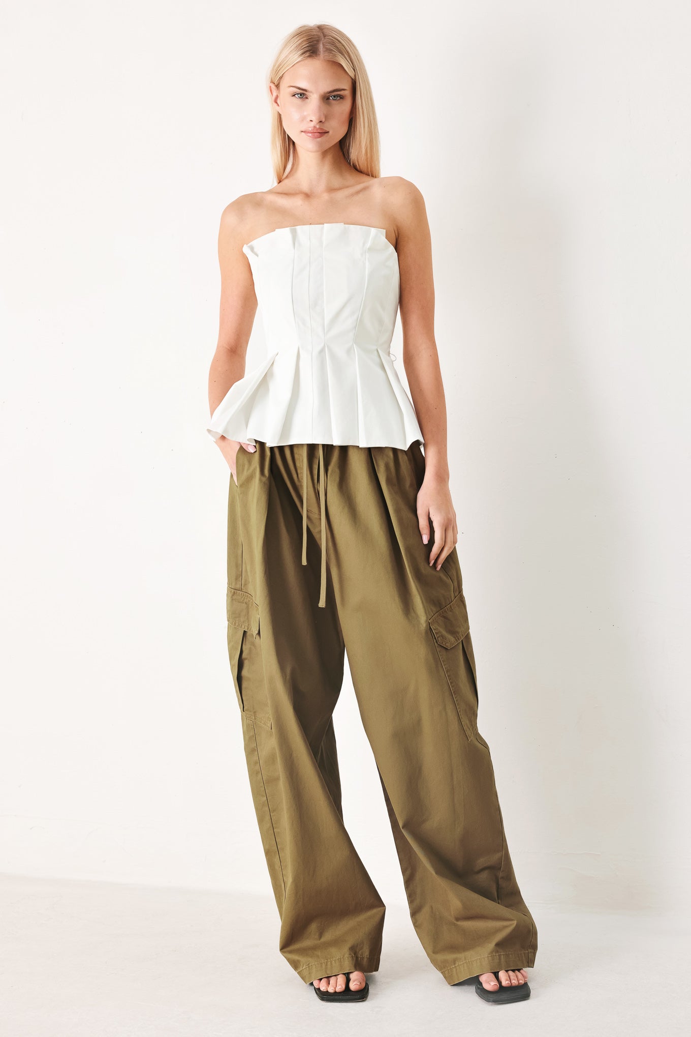 Woman wearing olive green wide-leg woven barrel pants with an elastic waist with contrasting tie and cargo pockets | FREEMARKET