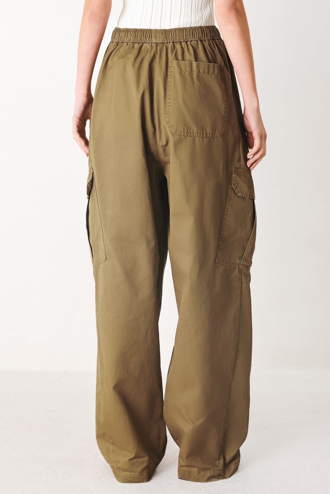 Woman wearing olive green wide-leg woven barrel pants with an elastic waist with contrasting tie and cargo pockets | FREEMARKET