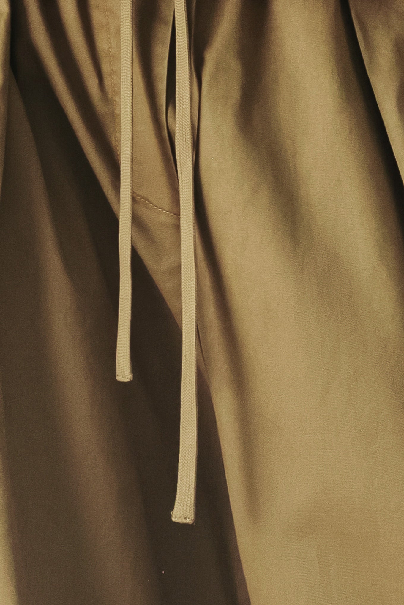 Close up of olive green wide-leg woven barrel pants with an elastic waist with contrasting tie and cargo pockets | FREEMARKET