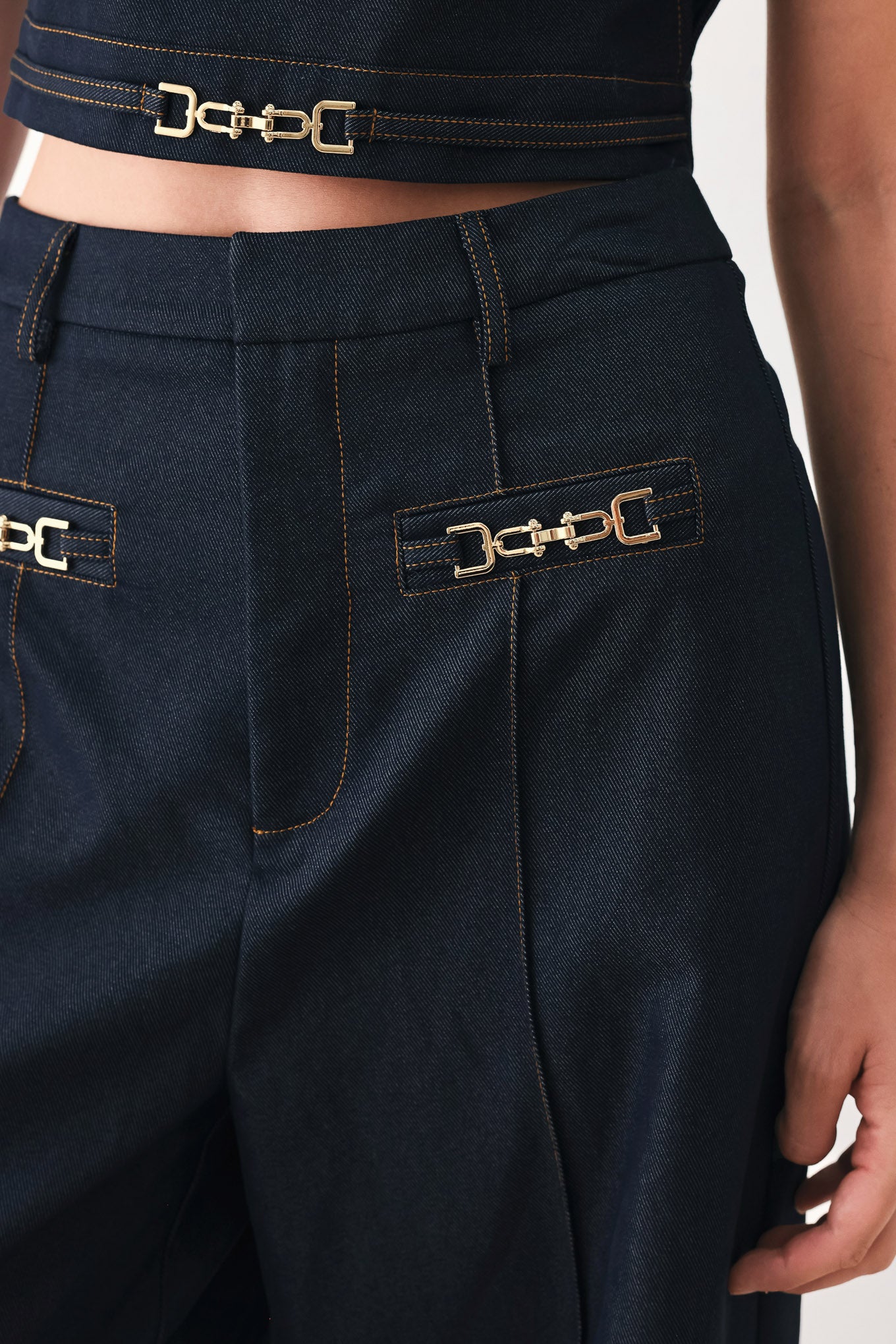 Woman wearing navy blue wide-leg pants with gold belt details | FREEMARKET