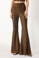 Woman wearing brown patterned bell-bottom pants with flare leg and back zipper closure | FREEMARKET