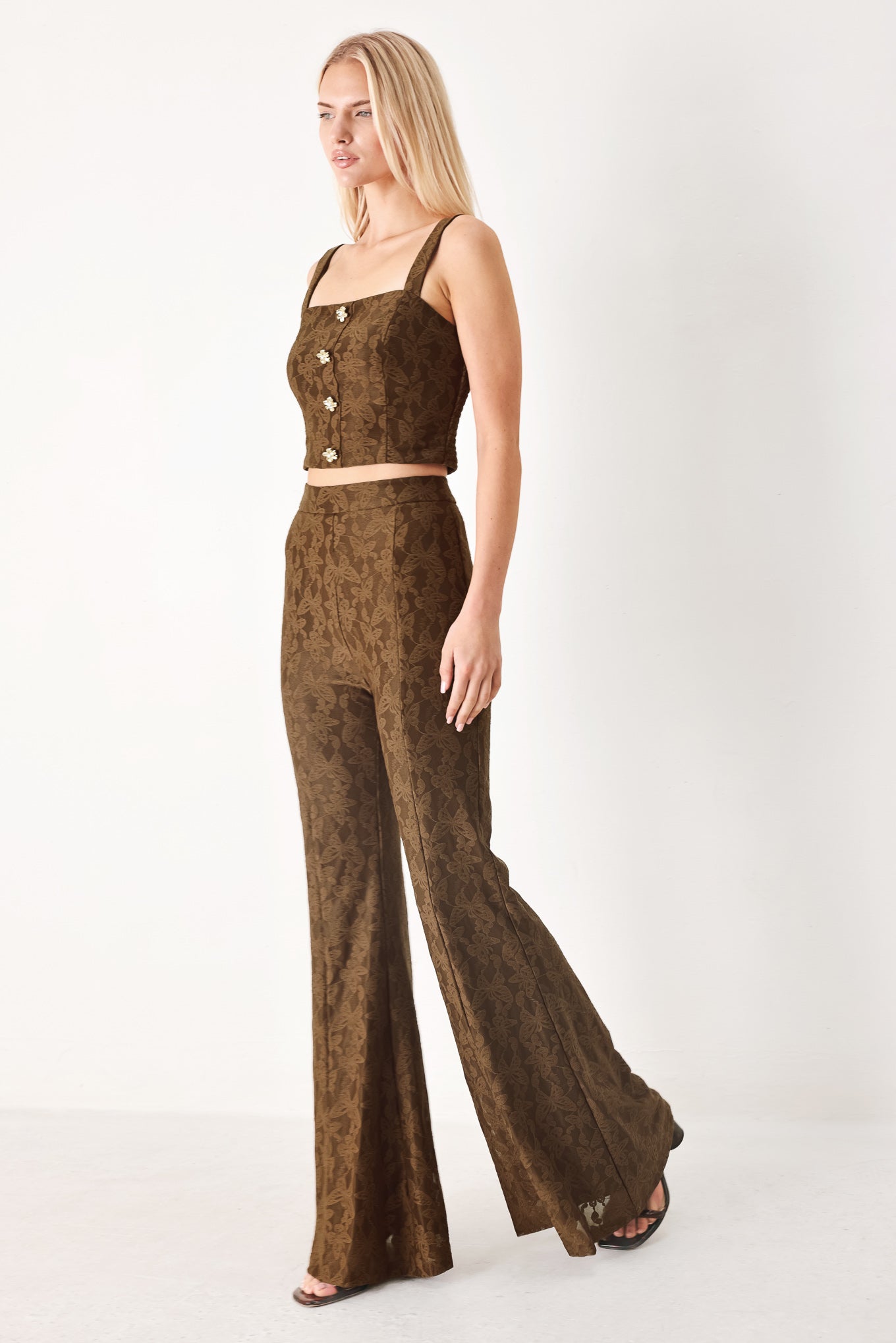 Woman wearing brown patterned bell-bottom pants with flare leg and back zipper closure | FREEMARKET
