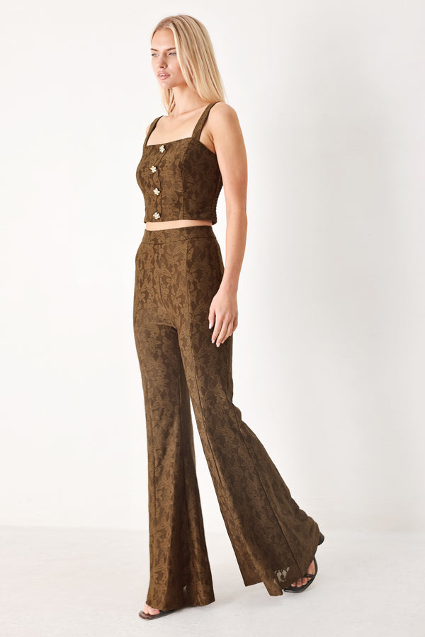 Woman wearing brown patterned bell-bottom pants with flare leg and back zipper closure | FREEMARKET