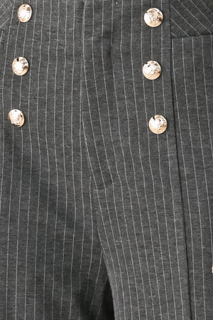 Woman wearing high-waisted, wide-leg charcoal gray and white pinstriped trousers with decorative gold-tone buttons on the front waistband | FREEMARKET