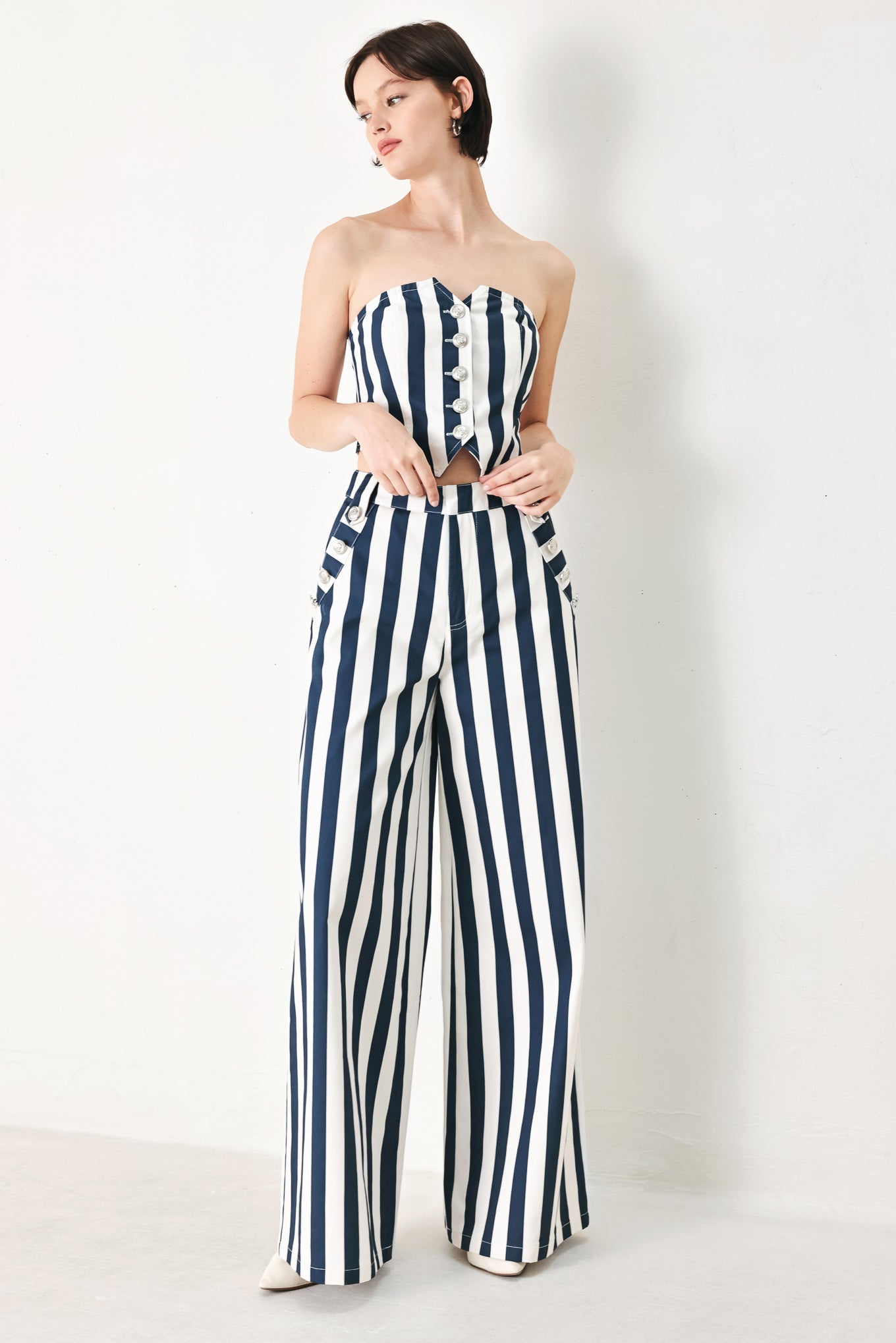 A printed woven pant featuring front closure, side pocket with button detail and wide leg