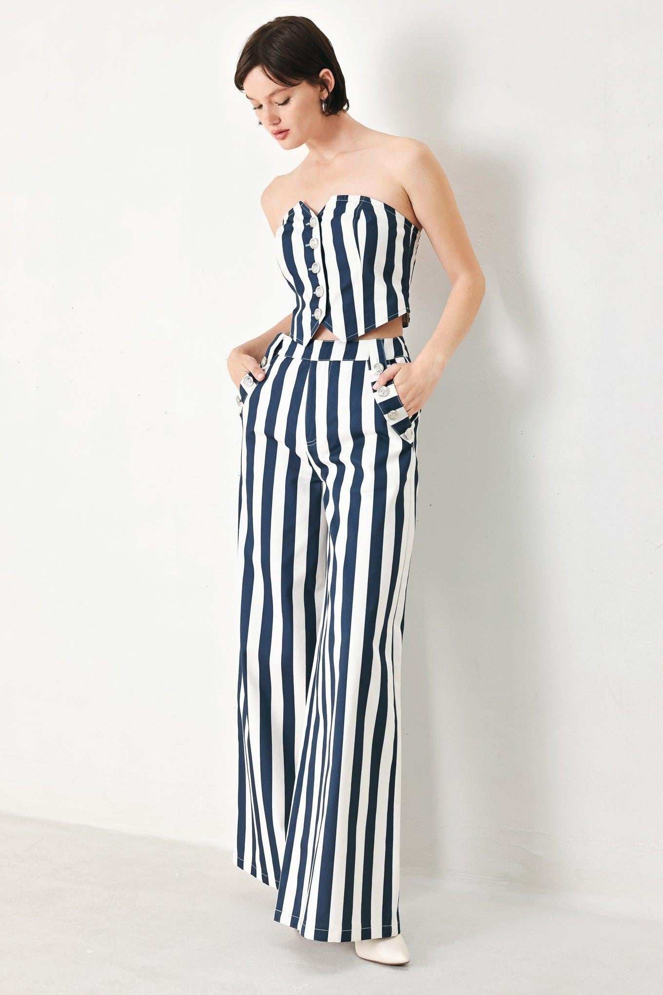 A printed woven pant featuring front closure, side pocket with button detail and wide leg