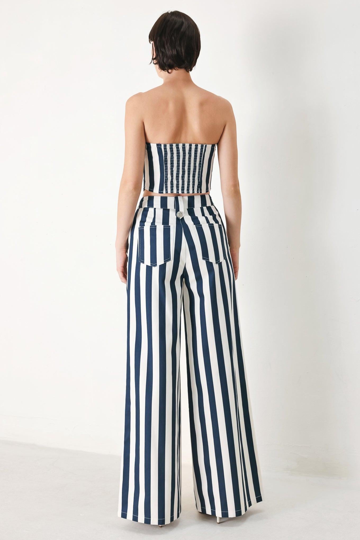 A printed woven pant featuring front closure, side pocket with button detail and wide leg