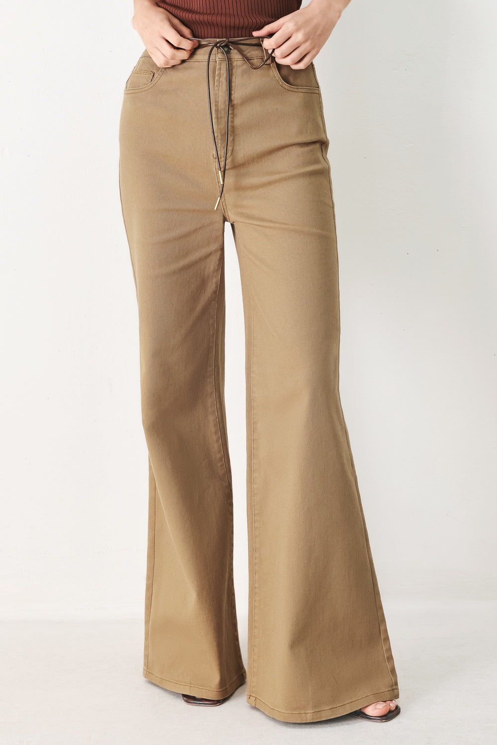 Woman wearing khaki wide-leg pants with front closure and contrasting belt | FREEMARKET