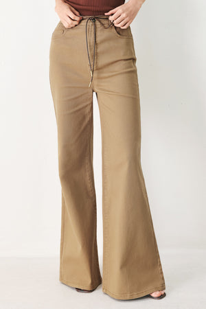 Woman wearing khaki wide-leg pants with front closure and contrasting belt | FREEMARKET