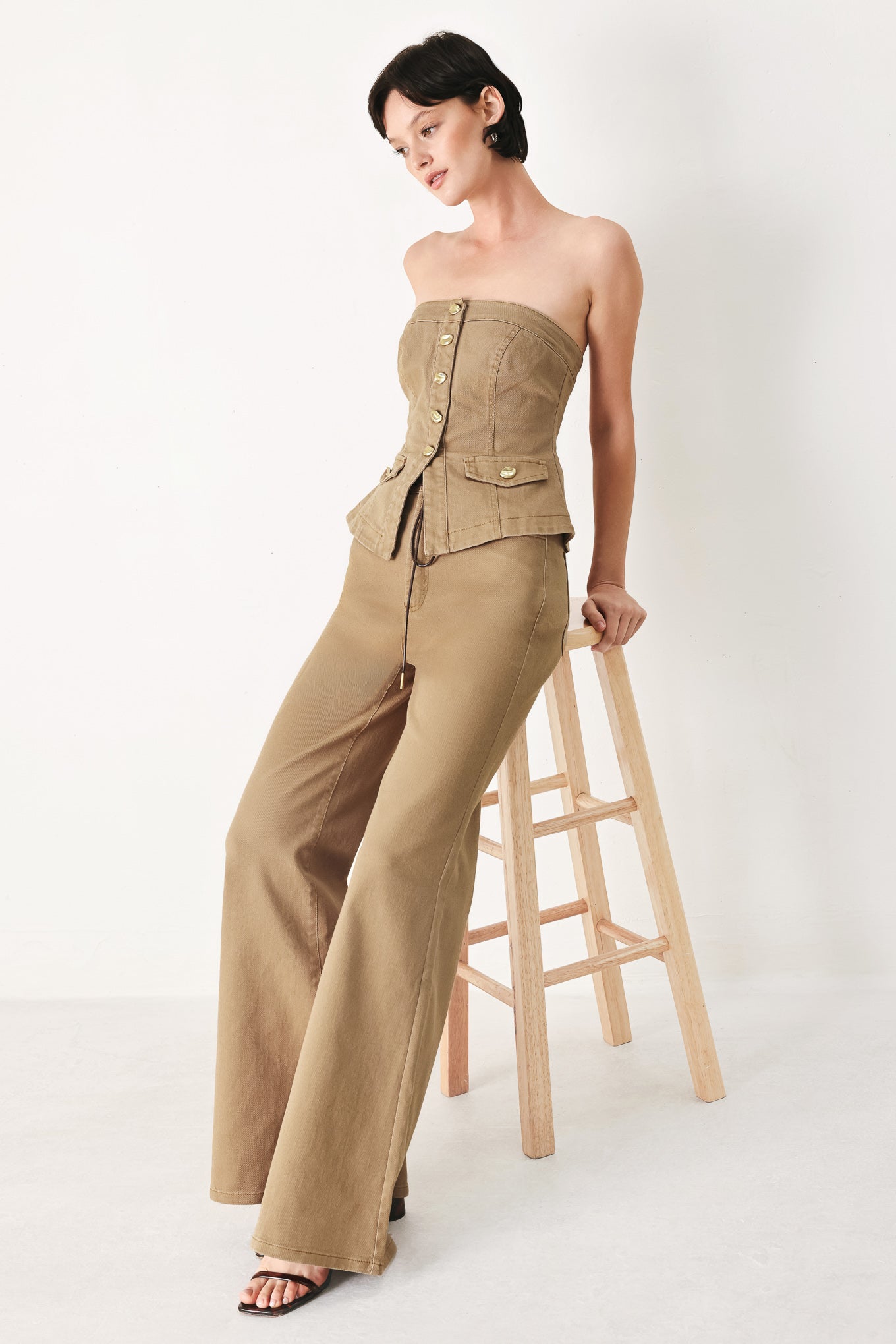 Woman wearing khaki wide-leg pants with front closure and contrasting belt | FREEMARKET