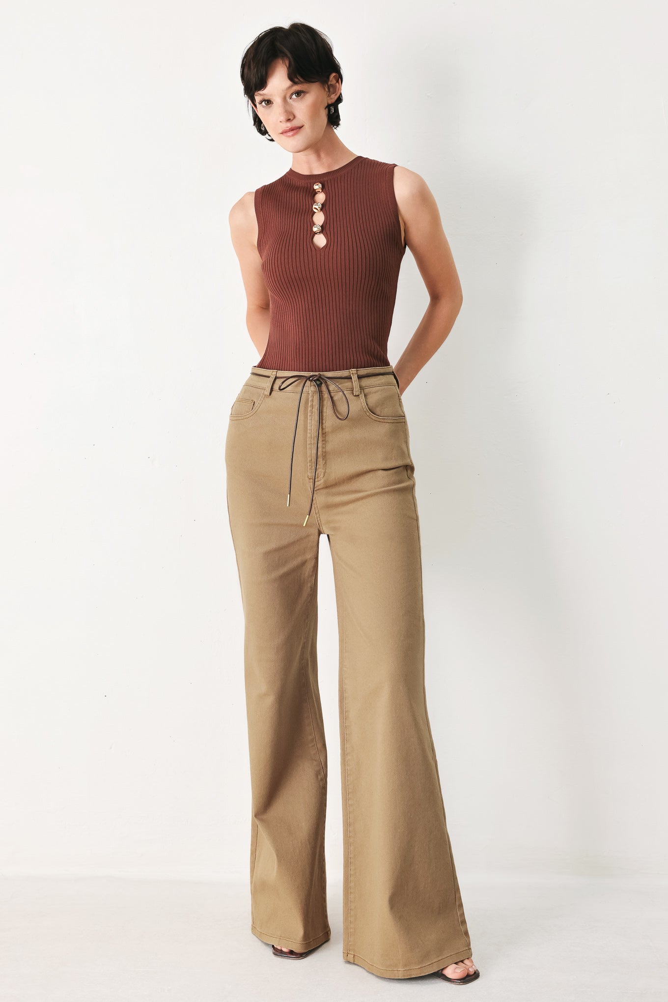 Woman wearing khaki wide-leg pants with front closure and contrasting belt | FREEMARKET