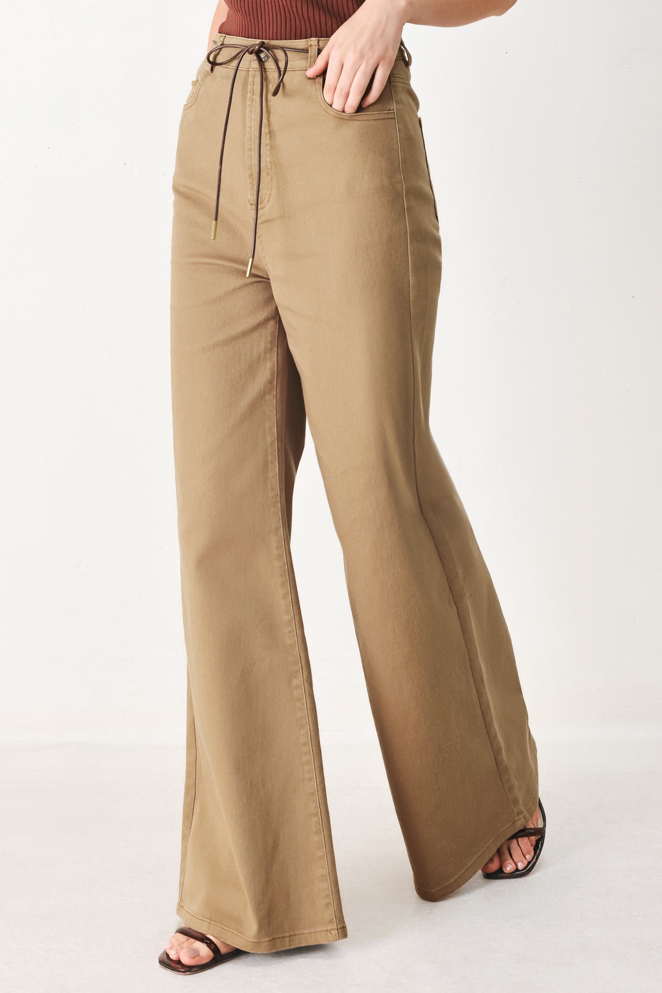 Woman wearing khaki wide-leg pants with front closure and contrasting belt | FREEMARKET